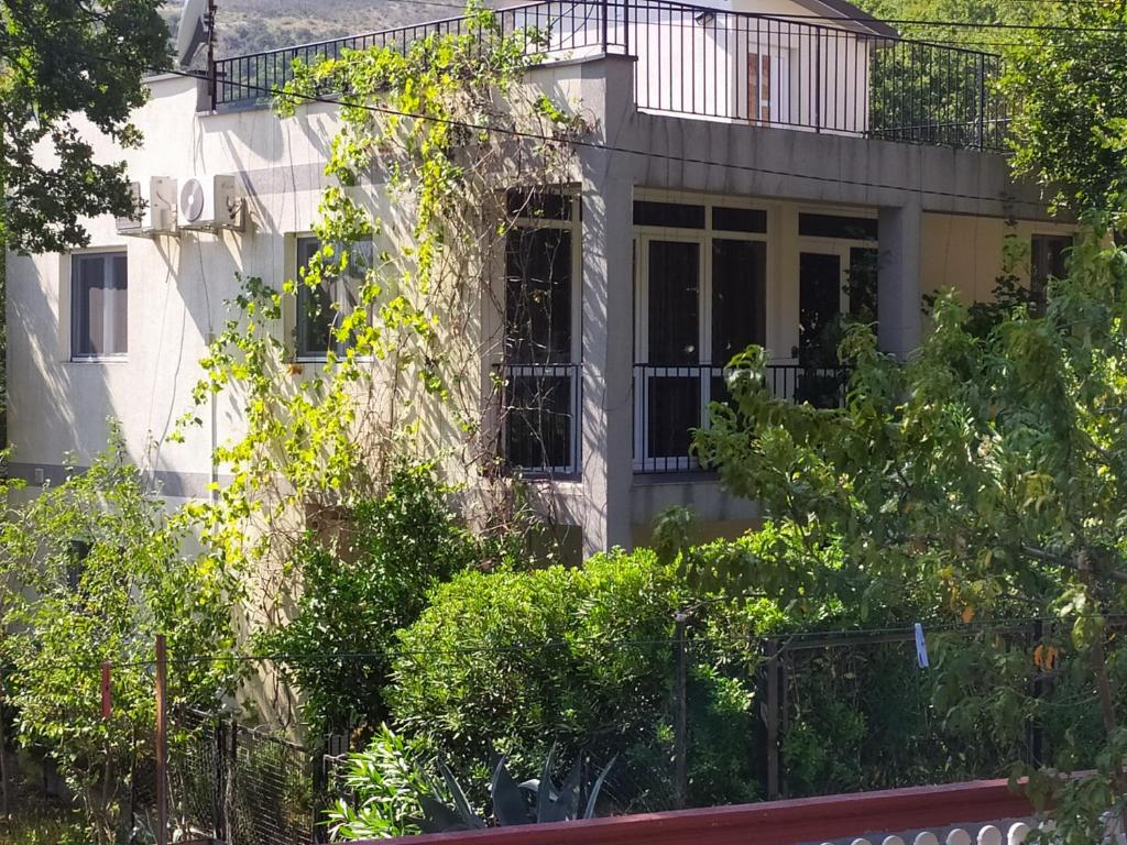 a white house with a fence in front of it at Villa Nadija in Čanj