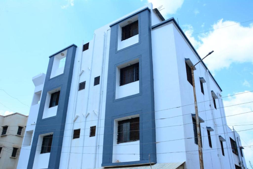 a white building with windows on the side of it at Hotel Sai Sulochana in Shirdi