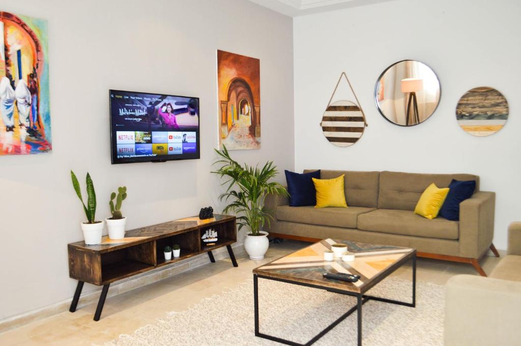 - un salon avec un canapé et une télévision dans l'établissement Cosy Triplex in La Marsa - 3 bed 2 Bath, à La Marsa