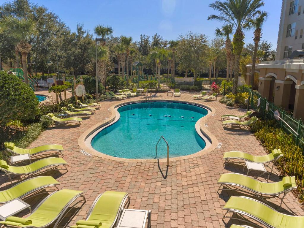 a swimming pool with lounge chairs in a resort at Holiday Inn Express & Suites S Lake Buena Vista by IHG in Kissimmee