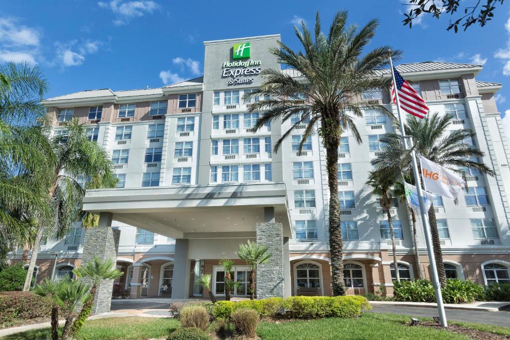 a hotel with palm trees in front of it at Holiday Inn Express & Suites S Lake Buena Vista by IHG in Kissimmee