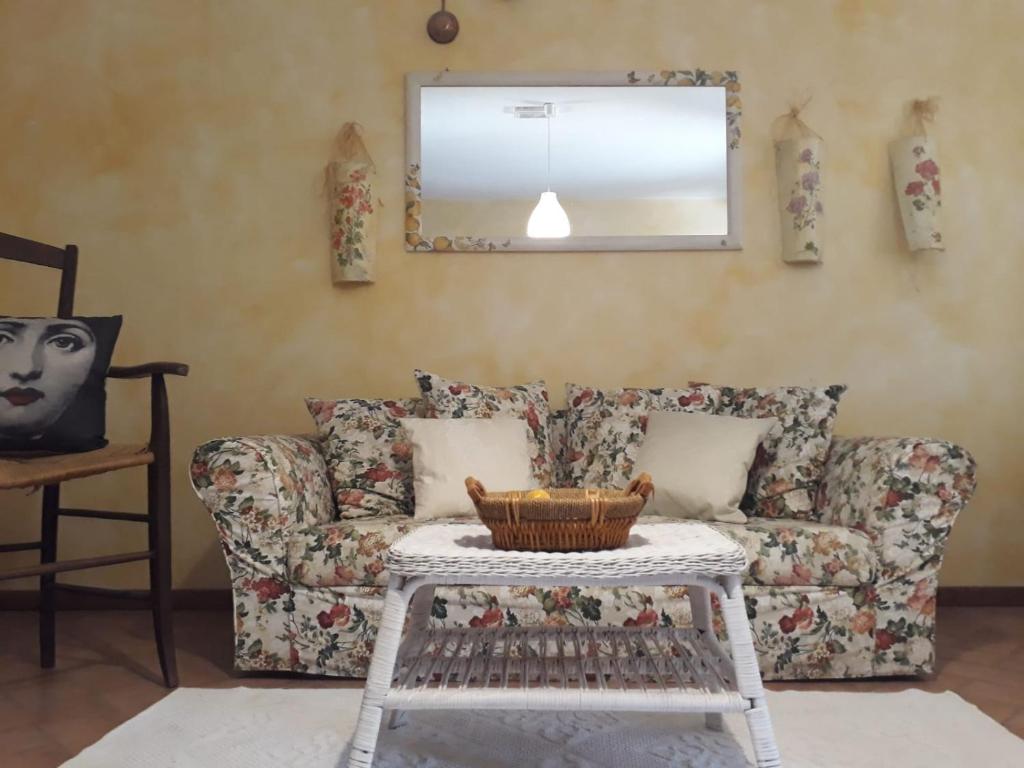 a living room with a couch and a mirror at Agriturismo L'Essiccatoio in Corgna
