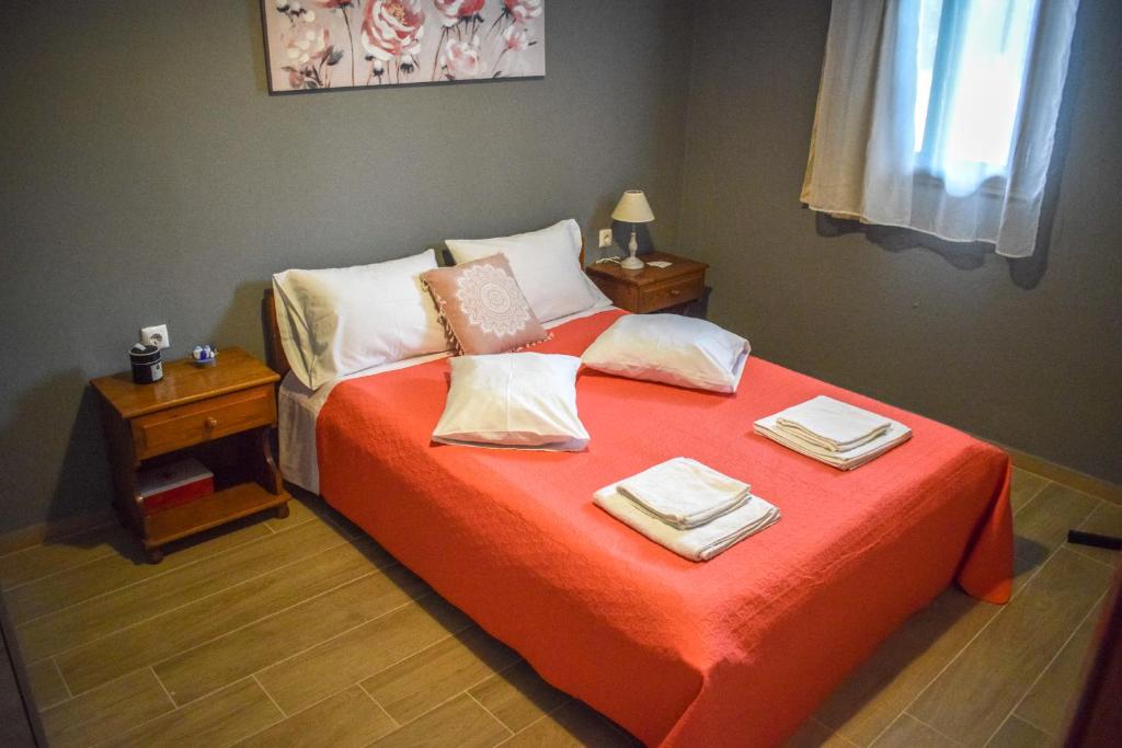 ein Schlafzimmer mit einem Bett mit zwei Handtüchern darauf in der Unterkunft Rose Garden Apartments in Mitikas