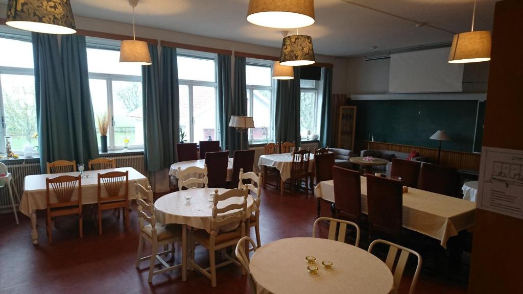 a dining room with tables and chairs and windows at Tossene Vandrahem in Hunnebostrand