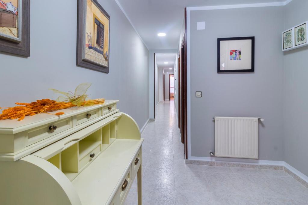 une cuisine avec un comptoir blanc et un couloir dans l'établissement Apartamento Vital Aza, à Pola de Lena