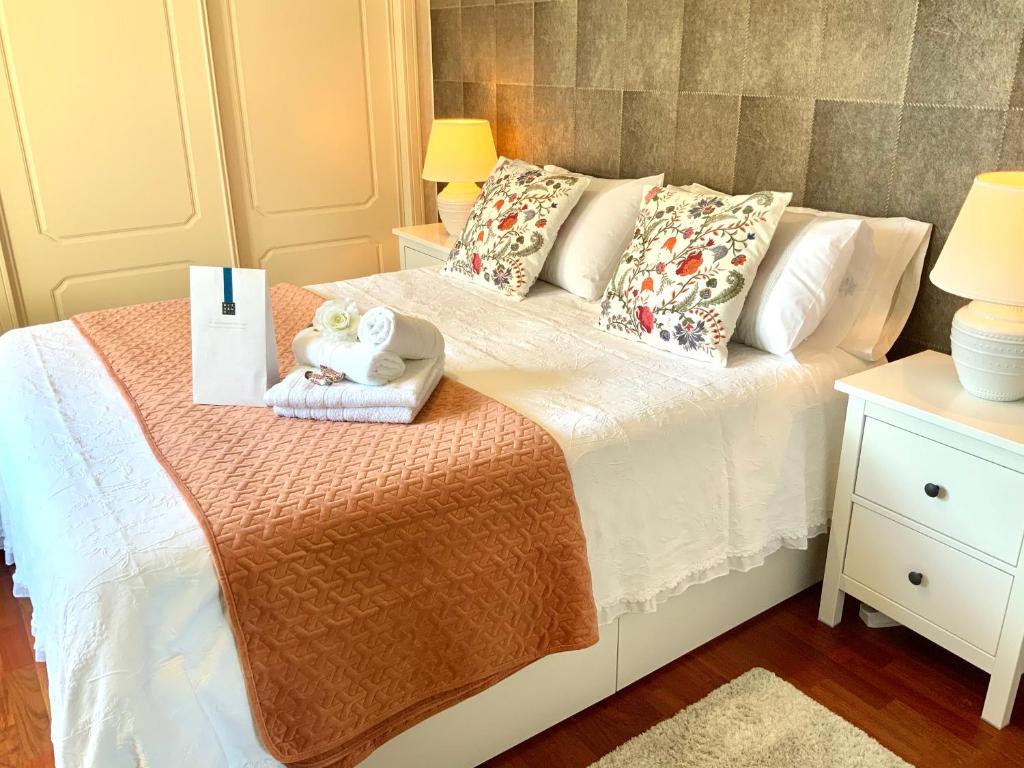 a bedroom with a bed with towels and pillows at PRECiOSO ÁTICO in Majadahonda