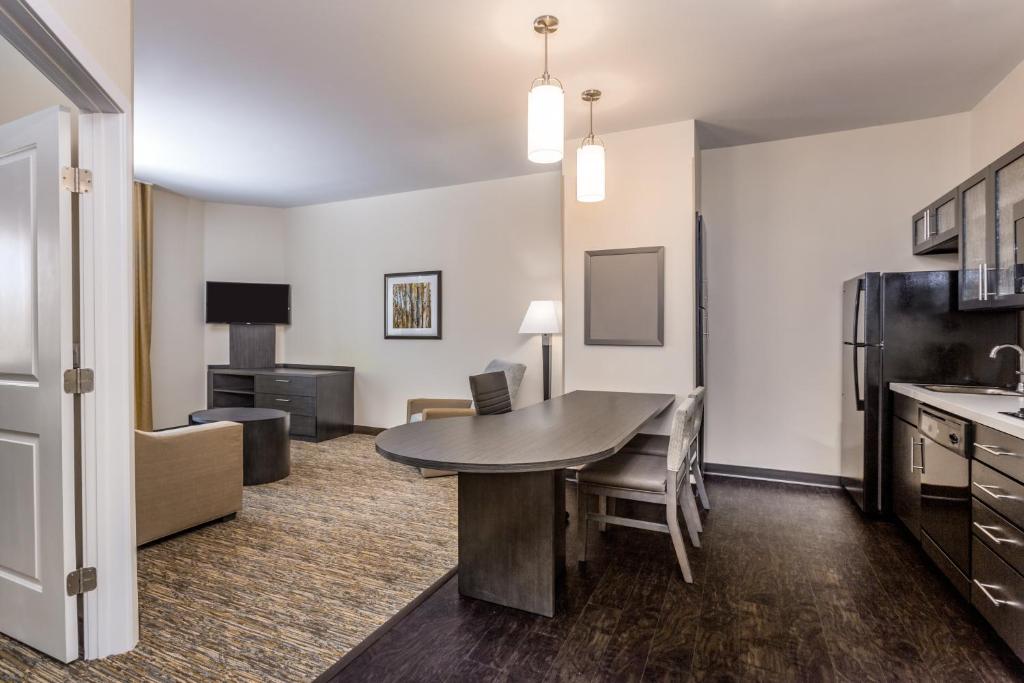 a living room with a table and a kitchen at Candlewood Suites Bethlehem South by IHG in Bethlehem