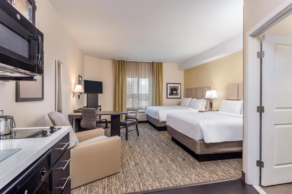 a hotel room with two beds and a kitchen at Candlewood Suites Bethlehem South by IHG in Bethlehem