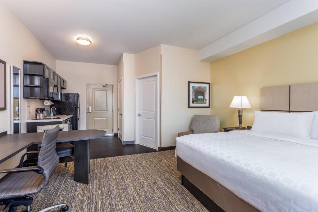 a hotel room with a bed and a desk at Candlewood Suites Bethlehem South by IHG in Bethlehem