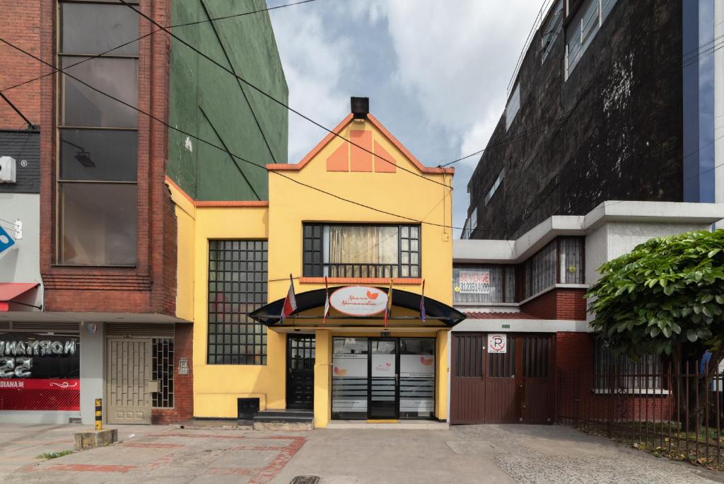 un edificio amarillo en el centro de los edificios en Hotel Nuevo Normandía, en Bogotá