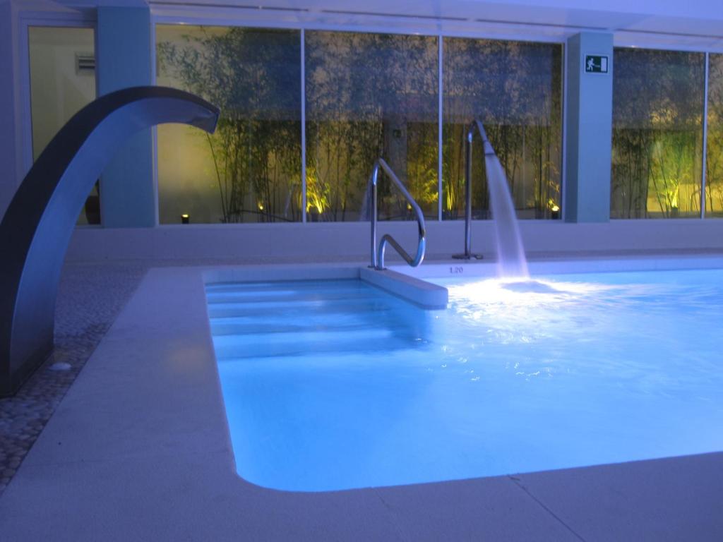 a swimming pool with a water fountain in a building at Del Mar Hotel & Spa in El Puerto de Santa María