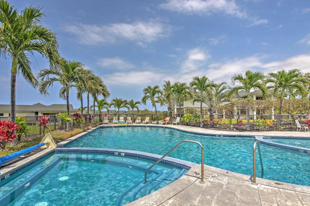 een zwembad met palmbomen in een resort bij Tropical Kona Resort Townhome Patio and Ocean Views in Kailua-Kona
