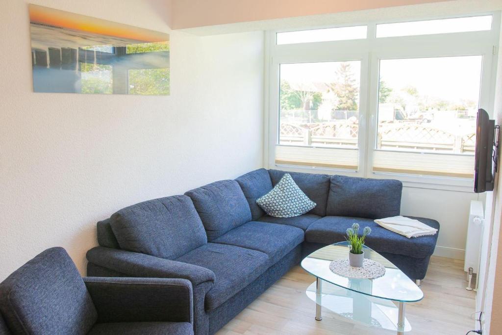 sala de estar con sofá azul y mesa en Haus-Strandburg-Seebriese, en Dahme