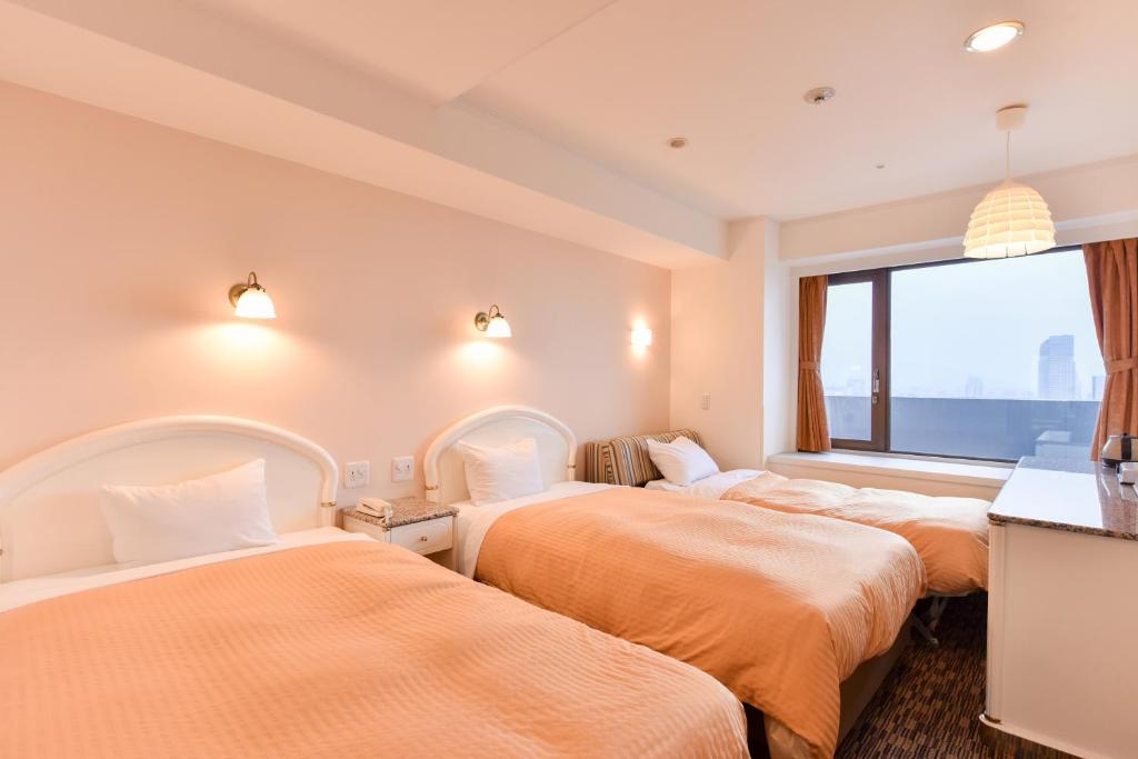 Postel nebo postele na pokoji v ubytování Kobe Sannomiya Union Hotel