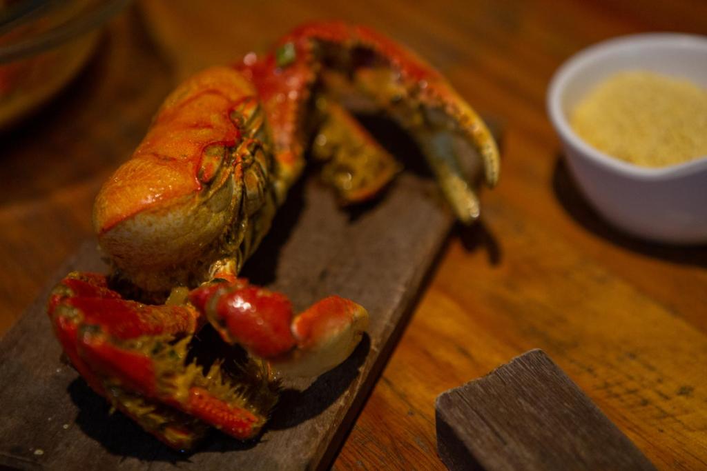 a wooden cutting board with food on a table at Pousada e Restaurante Altas Horas Beach in Itapipoca