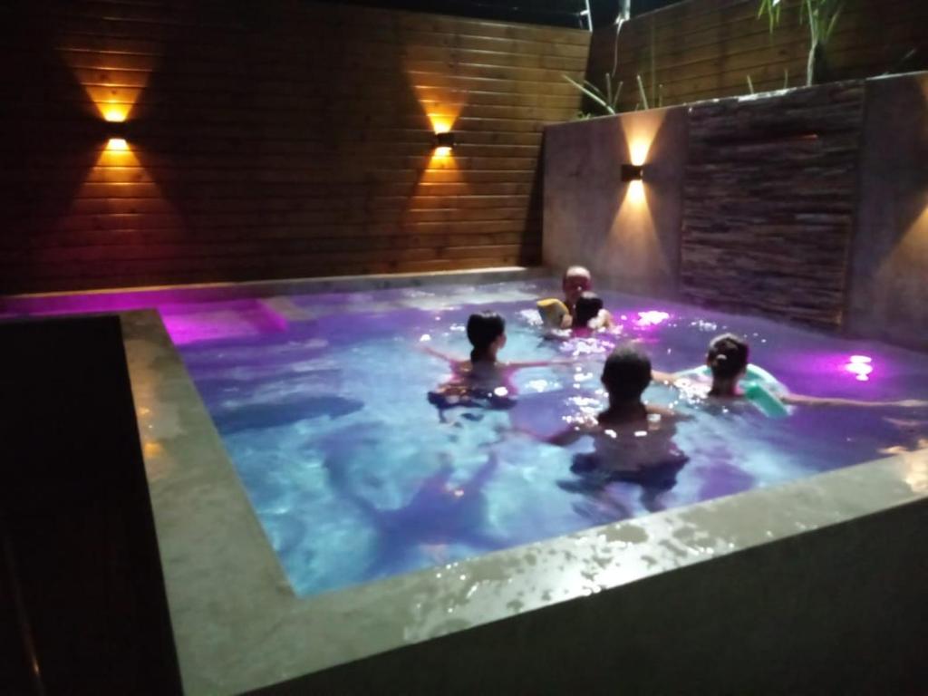 um grupo de pessoas em uma piscina à noite em Casa da Família em Nova Viçosa