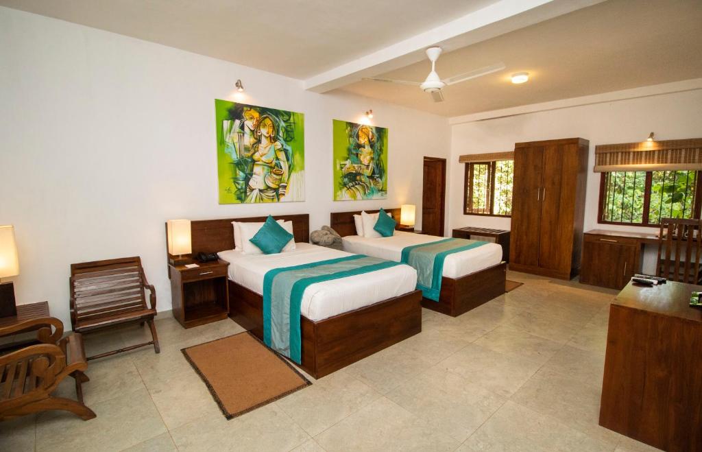 a bedroom with two beds and a desk and a chair at Amaara Forest Hotel Sigiriya in Sigiriya