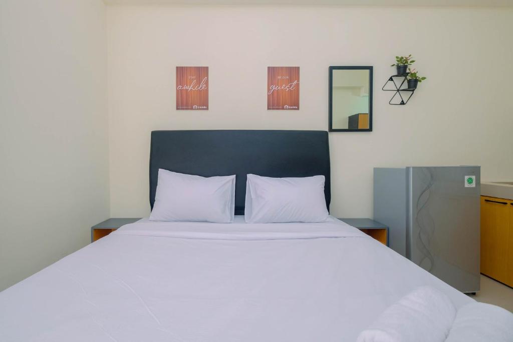 a bedroom with a large white bed with two pillows at Comfy Studio Bogorienze Apartment near The Jungle Fest By Travelio in Bogor