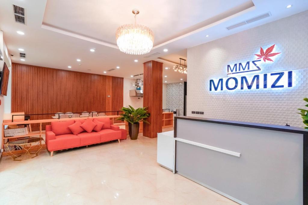 a lobby with a red couch and a sign at MOMIZI Hotel HAI PHONG in Hai Phong
