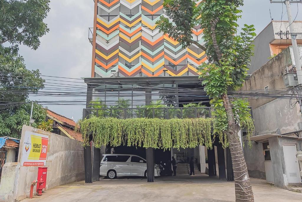 um edifício com um carro estacionado em frente em RedDoorz Premium @ Hotel Hebat em Bandung