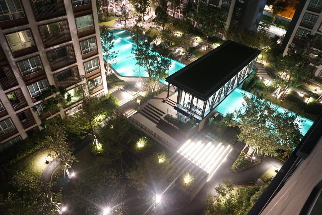una vista aérea de un edificio con piscina por la noche en Cozy room close to Central Festival in Chiangmai, en Chiang Mai
