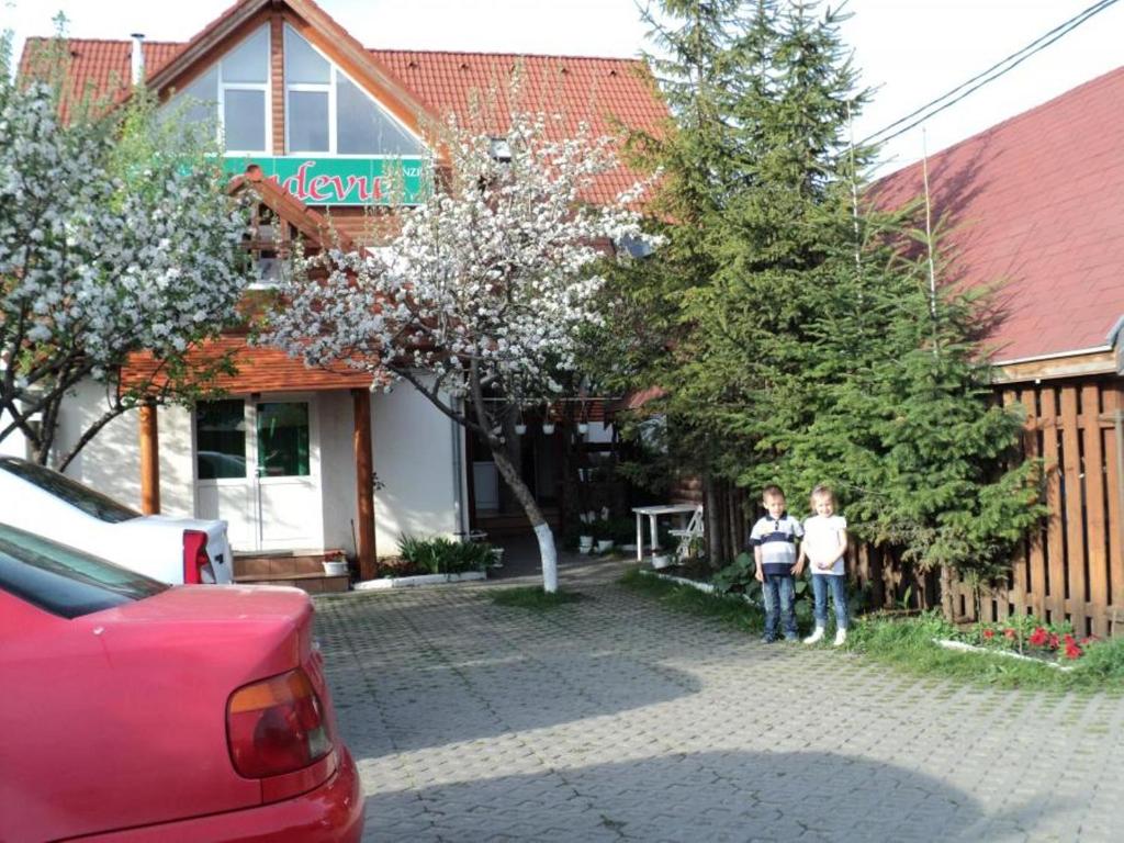 two children standing in front of a house at Randevú Panzió in Miercurea-Ciuc