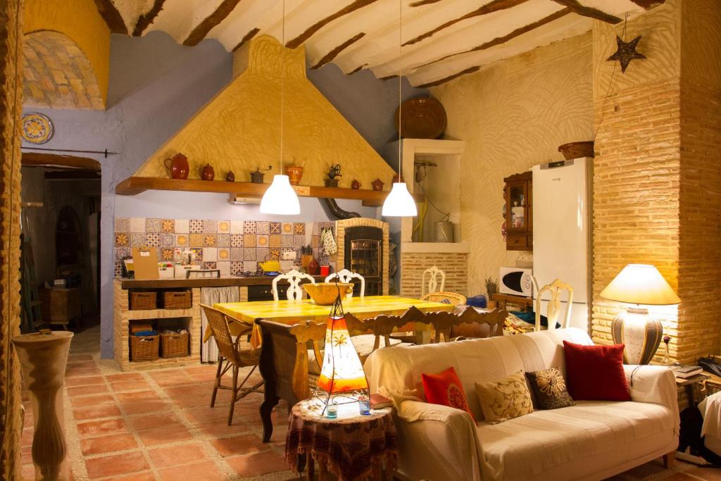 cocina y sala de estar con sofá y mesa en La Casa de la Florencia, en Higueruela