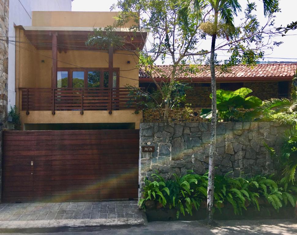 a house with a wooden gate and a stone wall at Urban Bliss Studio in Colombo