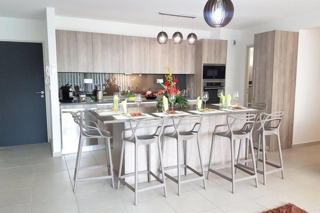 a kitchen with a large island with bar stools at City'appart in Papeete