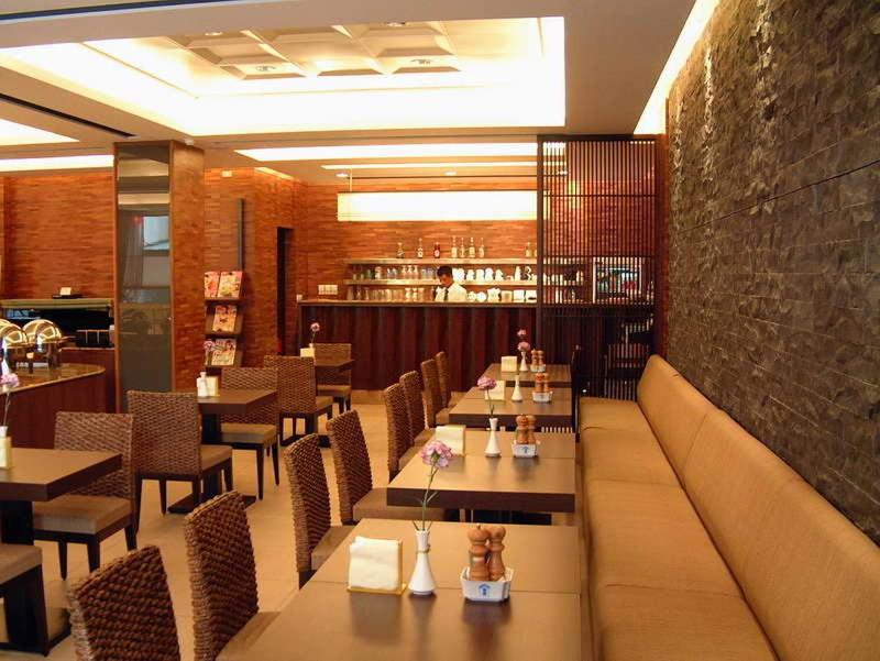 ein Restaurant mit Tischen und Stühlen in einem Zimmer in der Unterkunft The Premier Hotel in Tainan