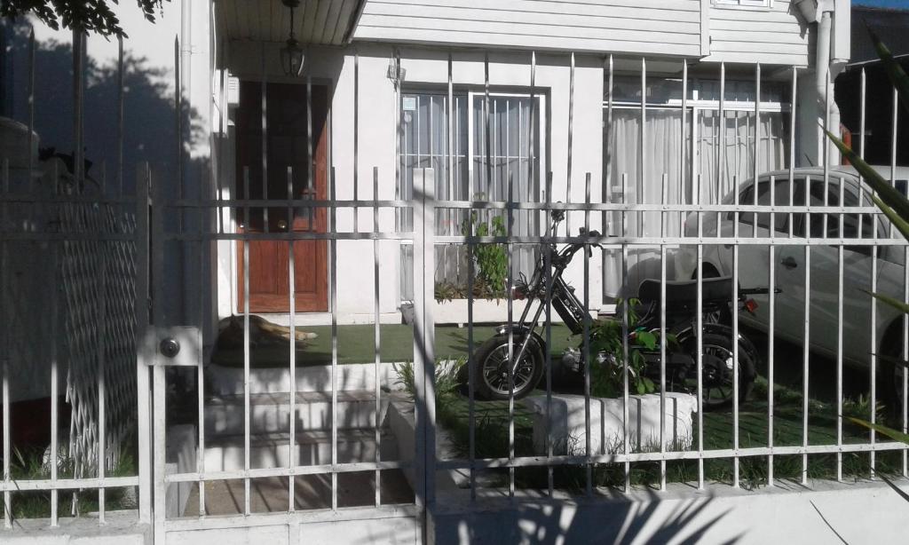 Una bicicleta en una valla delante de una casa en Alojamiento en Chillán, en Chillán