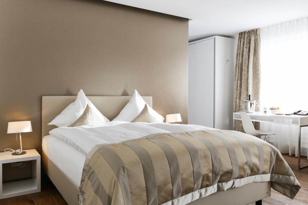 - une chambre avec un grand lit et un bureau dans l'établissement Hotel Uzwil, à Uzwil