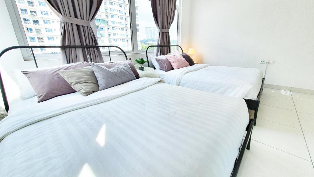 two beds in a room with a window at No.7 The Zebra @ Puchong Skypod Residence in Puchong