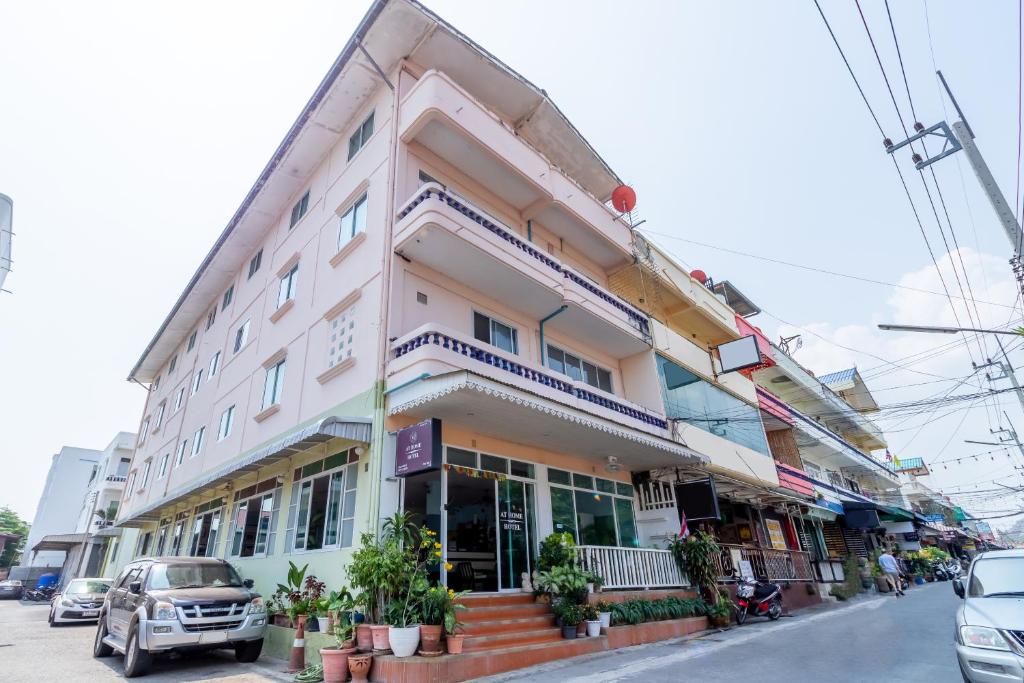 ein Gebäude auf einer Straße mit davor geparkt in der Unterkunft AT home hotel in Hua Hin