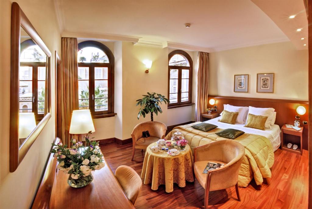 Un dormitorio con una cama y una mesa y sillas. en Hotel Ponte Sisto, en Roma