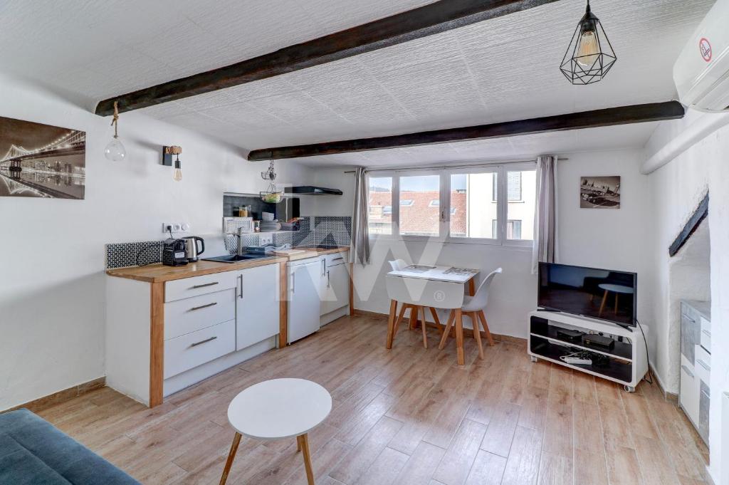 a kitchen with white cabinets and a kitchenette with a table at F2 Centre - Gare in Nice