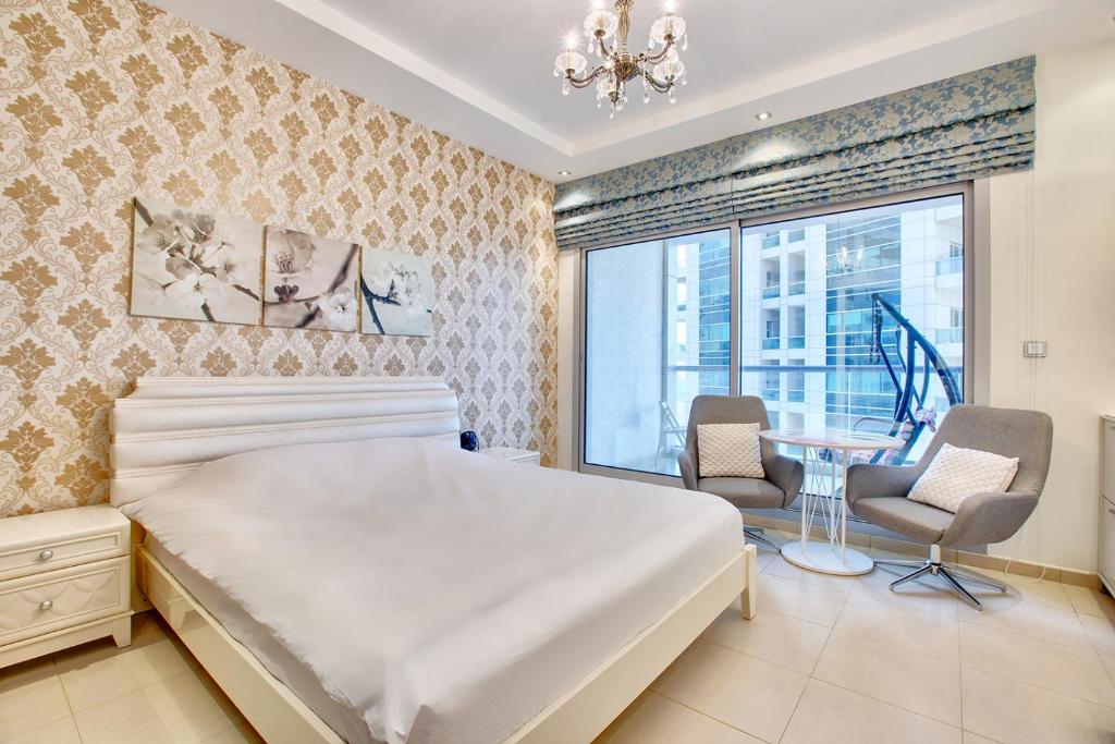 a bedroom with a large bed and a table and chairs at Cute Dubai Marina Studio in Skyview Tower in Dubai