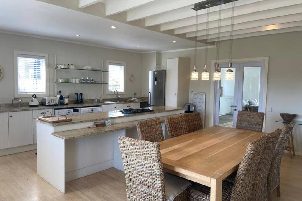 a large kitchen with a wooden table and chairs at Summit Song - Thesen Island in Knysna