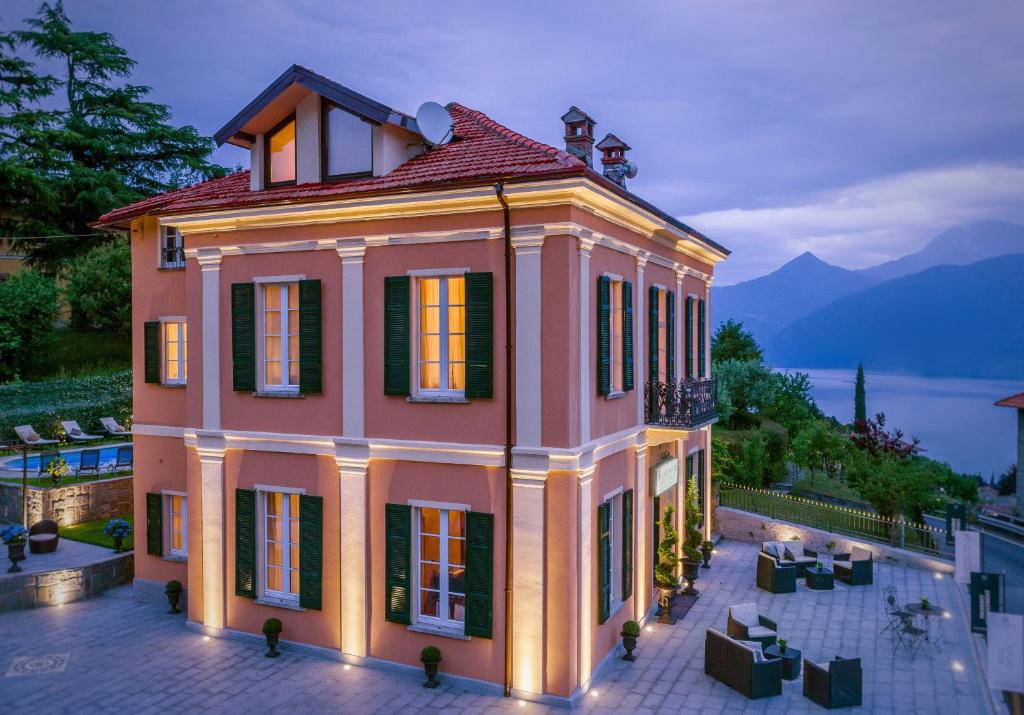 a large pink house with lights on at The Lake Como Villa in Menaggio