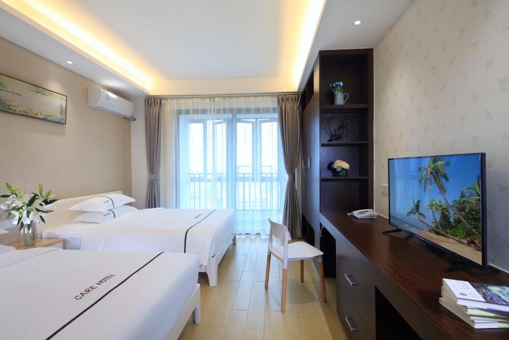 海口的住宿－克拉尔绿邸酒店(免费24小时美兰机场/动车接送)，酒店客房设有两张床和一台平面电视。