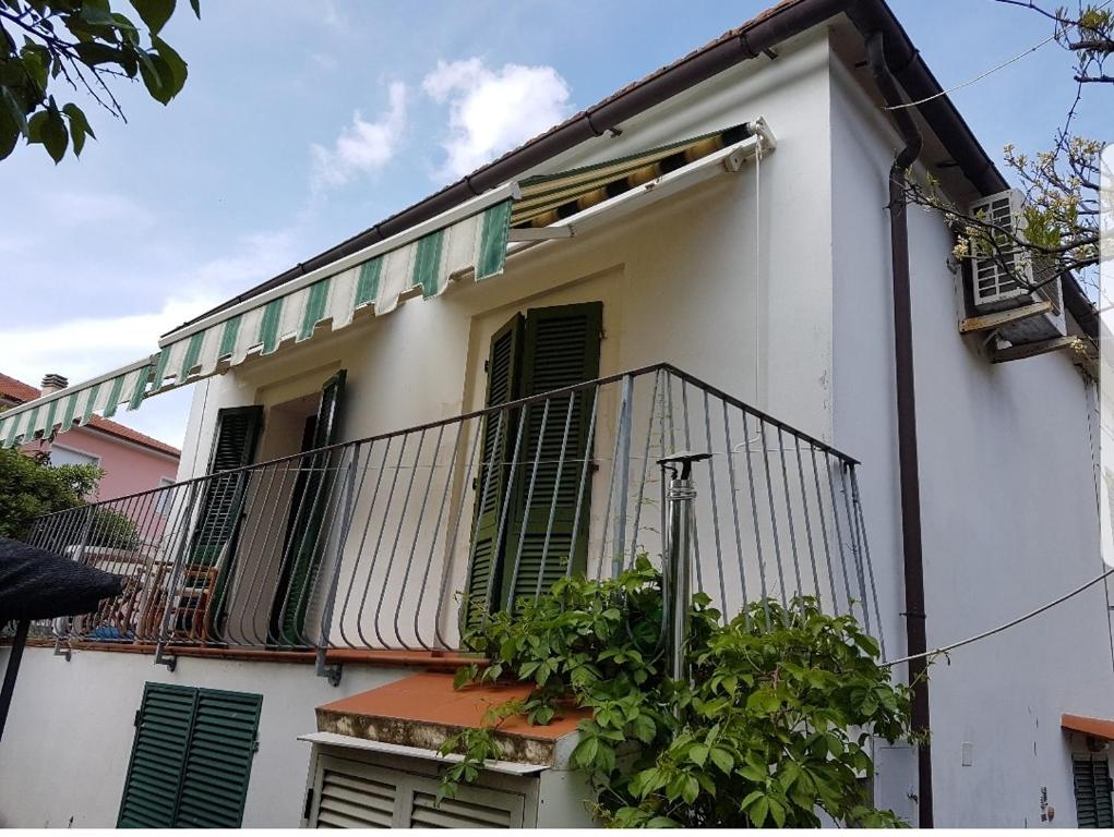 un edificio bianco con persiane verdi e balcone di Cavo Beach 1 a Cavo