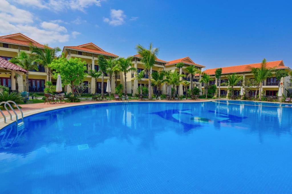 a large blue swimming pool in front of condos at MANLI Resort Quảng Bình in Dong Hoi