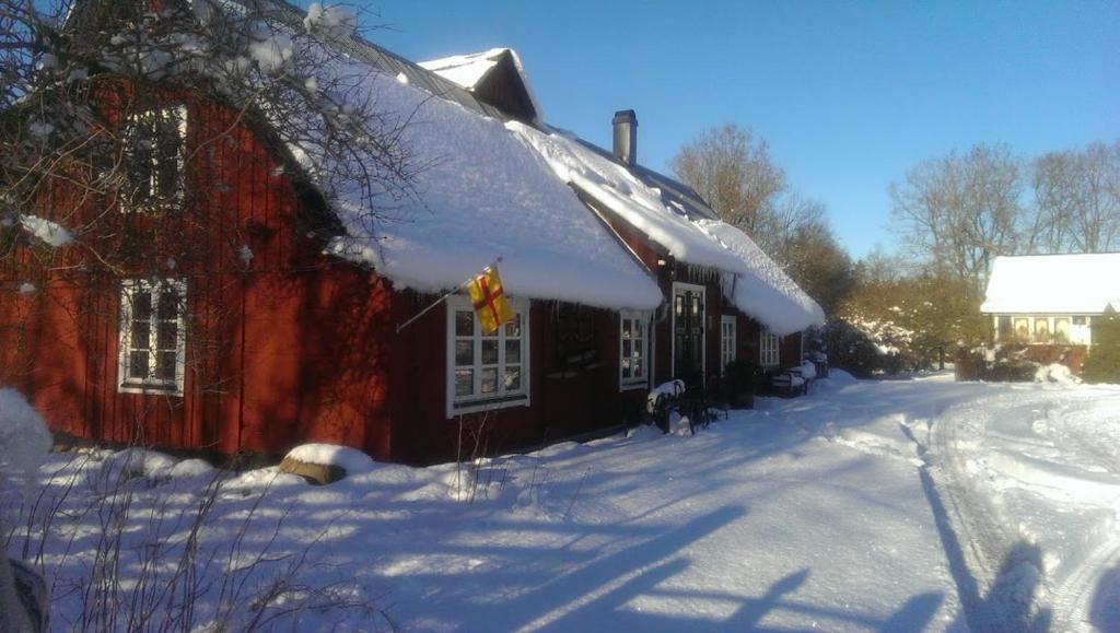 un granero rojo con nieve en el techo en Rögnaröd 4604, en Ljungbyhed