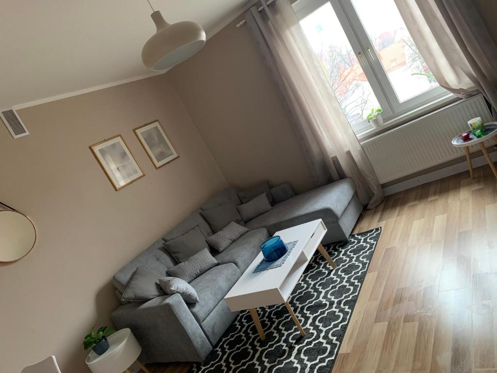 salon z kanapą i stołem w obiekcie Apartament „Ogrodowa” w mieście Bolesławiec