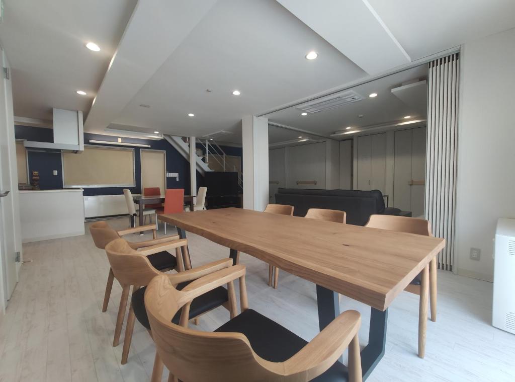 una sala de conferencias con mesa de madera y sillas en Private House Naturwald, en Furano