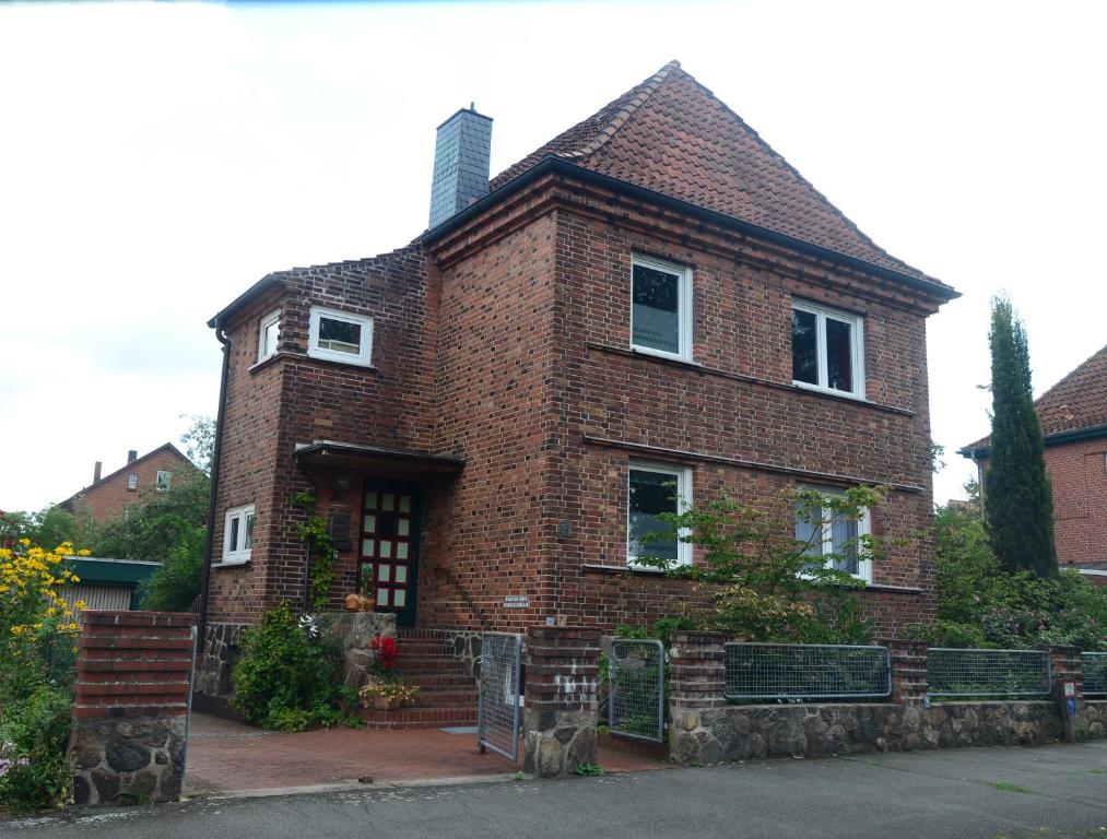 a red brick house with a roof at Appartements AM ROSENGARTEN in Celle
