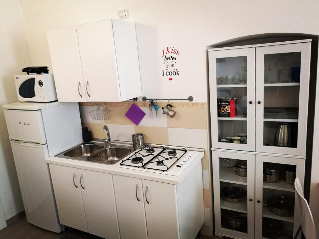 a small kitchen with a stove and a refrigerator at white house in Bari