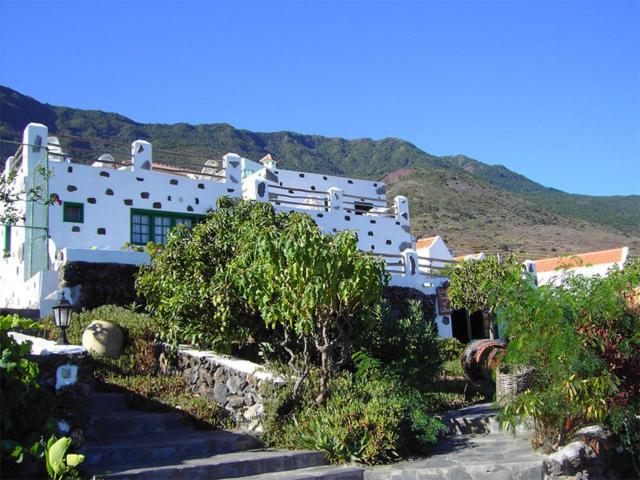 a large white building with stairs in front of a mountain at La Brujita in Frontera