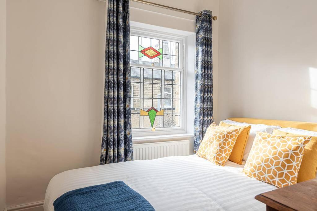 1 dormitorio con 1 cama y una ventana con cortinas en Cosy Mill Workers Cottage Heritage Saltaire en Shipley