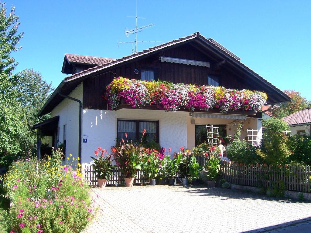 una casa con tanti fiori davanti di Haus Schmid a Innernzell